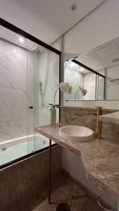 y baño con lavabo y ducha acristalada. en Sanches Le Premier, en São Paulo