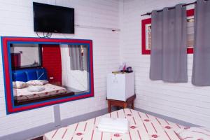 a mirror in a room with a bed and a television at Hotel e Motel Madrugada in Itu