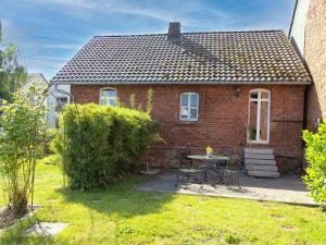 a brick house with a table and chairs in the yard at Schuster Bude in Münchhausen