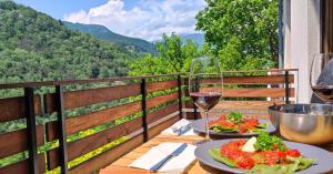 a table with two plates of food and a glass of wine at Moksha Slovenia in Tolmin