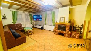 a living room with a couch and a fireplace at Casa din Vale in Moieciu de Sus