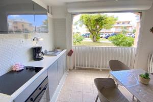 a kitchen with a sink and a table with chairs at Flamboyant Oasis in Baie Nettle