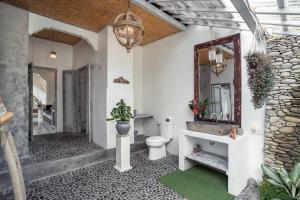ein Badezimmer mit einem WC, einem Spiegel und einem Waschbecken in der Unterkunft BREATHE in @ Villa GAIA / PRIVATE Pool UBUD in Ubud