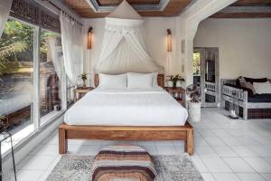 ein Schlafzimmer mit einem großen Bett in einem Zimmer mit Fenstern in der Unterkunft BREATHE in @ Villa GAIA / PRIVATE Pool UBUD in Ubud