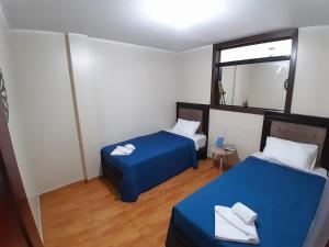 Habitación con 2 camas y espejo. en HOME BLESSED II, en Lima