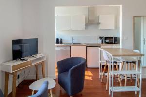 a kitchen with a table and chairs and a television at Unique et élégant, gare hyper centre wifi in Vernon