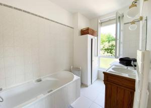 a white bathroom with a tub and two sinks at Unique et élégant, gare hyper centre wifi in Vernon