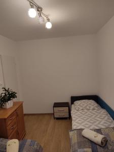 - une chambre avec un lit, une commode, un lit et une table de nuit dans l'établissement Pokoje_Zbąszyń, à Zbąszyń
