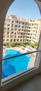 uma vista para uma piscina a partir da varanda de um edifício em Florenza khamseen resort em Hurghada