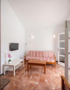 a living room with a couch and a table at Bungalows Las Almenas in Maspalomas +52 photos