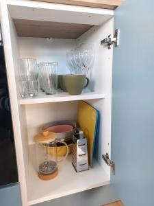 a cupboard with bowls and other kitchen utensils at Cathedral Quarter Apartments in Derry Londonderry