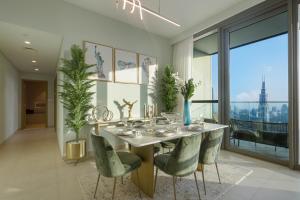 a dining room with a table and green chairs at 3+1 BR, Burj Khalif, Dubai Mall in Dubai