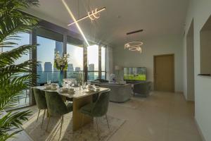 a dining room with a table and chairs and a living room at 3+1 BR, Burj Khalif, Dubai Mall in Dubai