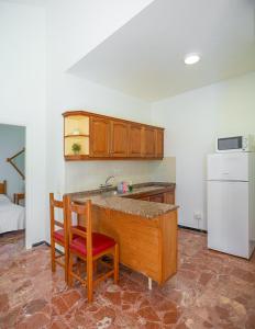 a kitchen with a counter and a sink and a refrigerator at Bungalows Las Almenas in Maspalomas