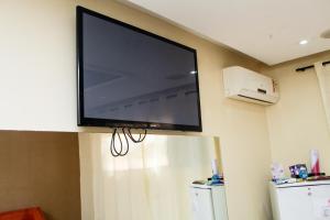 a flat screen tv hanging on a wall at Hotel e Motel Madrugada in Itu