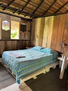 a bedroom with a bed in a wooden room at EcoHostal Nature EcoFit 06 in Playa Punta Arena