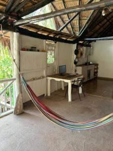 a hammock in a room with a table and a laptop at EcoHostal Nature EcoFit 06 in Playa Punta Arena