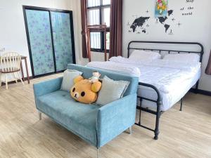 a bedroom with a bed and a chair with a teddy bear at Modern Loft Style in Nakhon Phanom