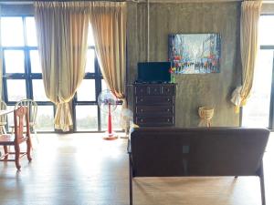 sala de estar con sofá y algunas ventanas en Modern Loft Style, en Nakhon Phanom