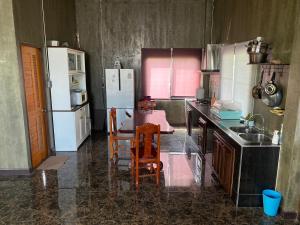 eine Küche mit einem Tisch und Stühlen sowie einem Kühlschrank in der Unterkunft Modern Loft Style in Nakhon Phanom