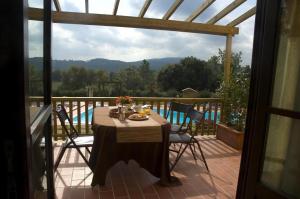 einen Tisch auf einem Balkon mit Poolblick in der Unterkunft Agriturismo La Burraia in Gambassi Terme
