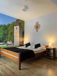 a bedroom with a large bed with a clock on the wall at Krokus in Sromowce Niżne