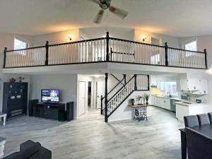 a living room with a staircase and a kitchen at Forest Retreat - Pool - Games - Fireside Joy in Cayuga