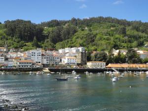 a group of boats in the water near a city at Apartamentos Sarga Sentirgalicia in Cabañas