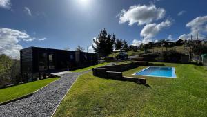 a house with a swimming pool in the grass at Huinanco Lodge in Concepción