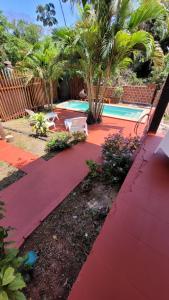 a garden with a red walkway next to a swimming pool at Hostel Haus in Puerto Iguazú