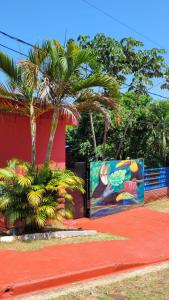 a building with palm trees and a mural at Hostel Haus in Puerto Iguazú