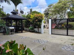 a black gate with a gazebo in a yard at Bella Homes 6BR near Rotunda, WiFi, Parking in Tagaytay