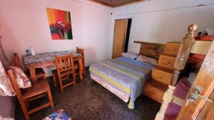een slaapkamer met een bed, een tafel en een bureau bij Hostel Haus in Puerto Iguazú