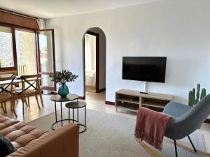 sala de estar con sofá y TV de pantalla plana en Apartamento El Olivo, en Noja