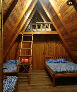a room with two bunk beds and a ladder at Cabaña del lago in Ciudad del Este