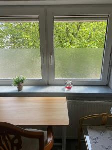 Monteur Gäste Zimmer Stadt Hafen في هوسوم: مكتب في غرفة بها نافذتين