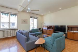 ein Wohnzimmer mit 2 blauen Sofas und einem TV in der Unterkunft [IHost Apartment] - Niccolini 21 in Mailand