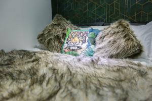 a bed with a tiger pillow and a blanket at B101 Boutique City Loft in Coventry