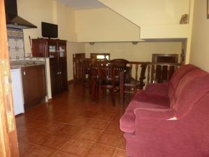 a living room with a couch and a table and chairs at Hotel Apartamentos La Hortona in Soto de Luiña