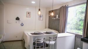 a small kitchen with a table and two chairs at STUDIO 301 | WIFI 600MB | RESIDENCIAL JC, um lugar para ficar. in Belém
