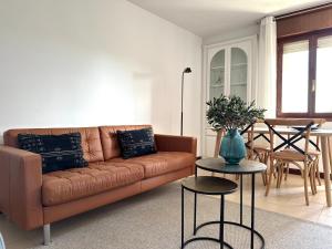 ein Wohnzimmer mit einem braunen Sofa und einem Tisch in der Unterkunft Apartamento El Olivo in Noja