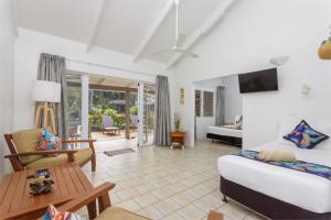 ein Wohnzimmer mit einem Bett und einem Tisch in der Unterkunft Rarotonga Daydreamer Escape in Rarotonga