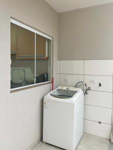 eine Küche mit einem weißen Kühlschrank und einem Fenster in der Unterkunft Casa completa e espaçosa in Foz do Iguaçu