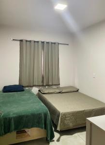 2 Betten in einem Zimmer mit Fenster in der Unterkunft Casa completa e espaçosa in Foz do Iguaçu