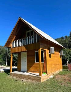 a small house with a porch and a balcony at Sítio Recanto Nativo in Palmitos