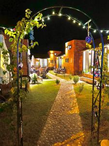 a garden at night with a string of lights at Alican İzba House in Cıralı
