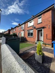 a brick house with a small tree in a yard at Tarleton house in Stoke on Trent