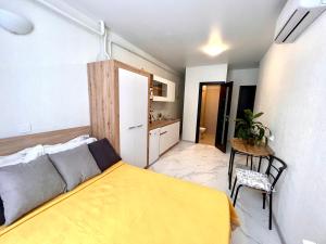 um quarto com uma cama amarela e uma mesa em Apart Hotel in a complex Semycvit em Lviv
