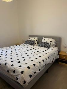 a bed with black and white sheets and pillows at New apt Stunning view steps from hospital! in Ramat Gan