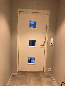 une porte blanche avec trois fenêtres dans une pièce dans l'établissement Fin leilighet i Tromsø, à Tromsø